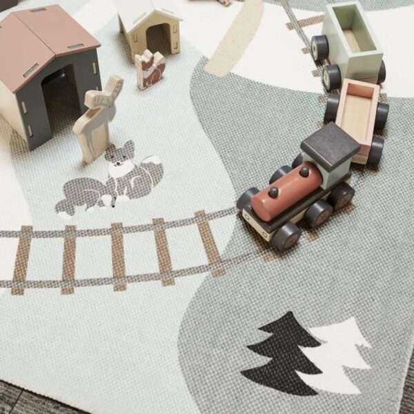 Train en bois sur un tapis de jeu décoré avec un paysage de forêt