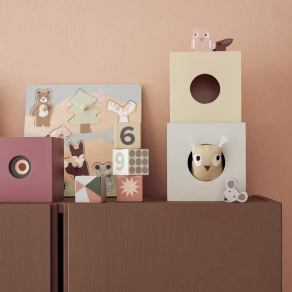 Puzzle en bois posé sur une étagère avec d'autres jouets en bois