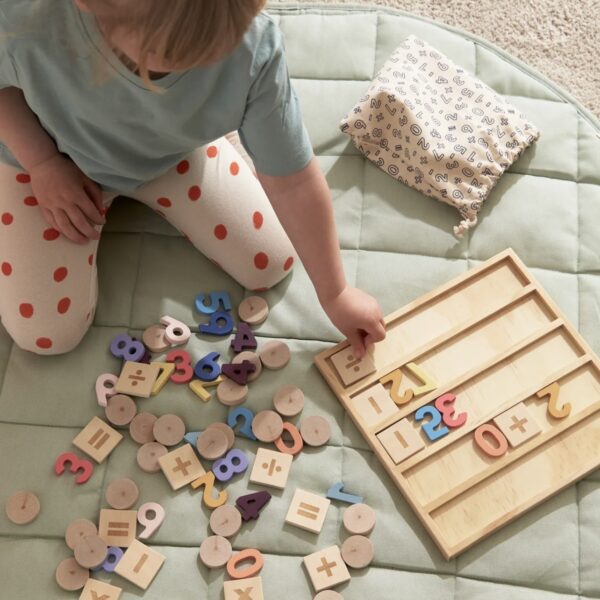 Enfant jouant avec plusieurs pièces en bois pour apprendre à lire, écrire et compter