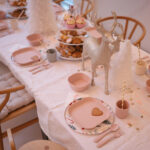 Une table décorée pour un anniversaire de petite fille avec de la vaisselle en plastique rose