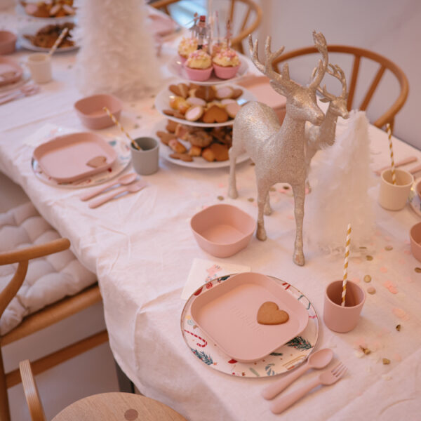 Une table décorée pour un anniversaire de petite fille avec de la vaisselle en plastique rose