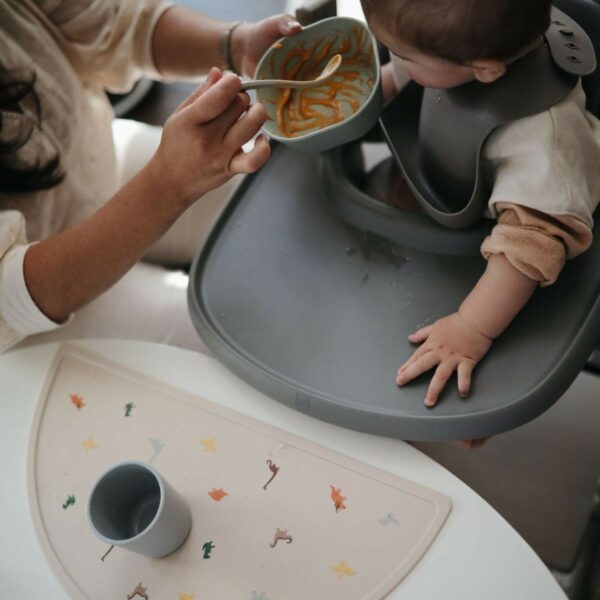 Une mère donnant à manger à son bébé dans sa chaise haute