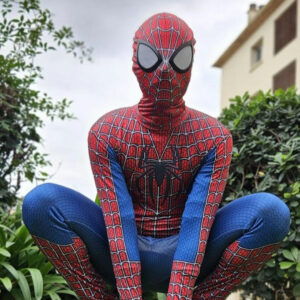 Une personne déguisée en superhéros spiderman dans un jardin extérieur
